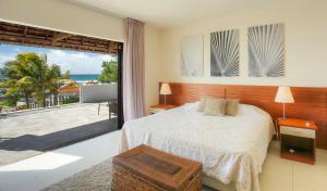 a bedroom with a bed and a view of the ocean at Peter's Beach House in Poste Lafayette