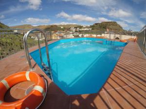 a swimming pool on the deck of a house at Apartamentos Tapahuga in Playa de Santiago