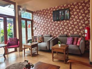 a living room with a couch and a tv on the wall at Wualai Boutique by Lanna Oriental in Chiang Mai