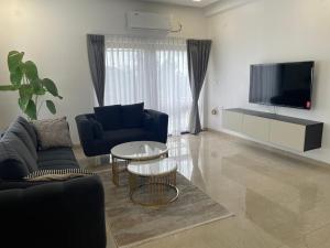 sala de estar con sofá, mesa y TV en Bridge Service Apartment, en Hyderabad