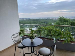 a table and chairs on a balcony with a view at Bridge Service Apartment in Hyderabad