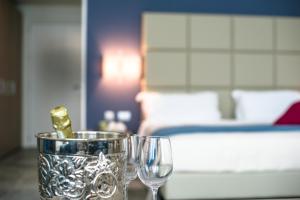 two wine glasses sitting on a table in a bedroom at Hotel Villa Borghi in Varano Borghi