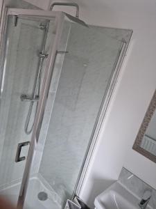 um chuveiro com uma porta de vidro na casa de banho em 3 bedroom house-Ellesmere Port em Ellesmere Port