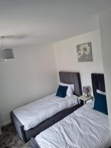 two beds sitting next to each other in a room at 3 bedroom house-Ellesmere Port in Ellesmere Port