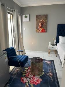 a living room with a blue chair and a table at WILLOW GUEST HOUSE in Boksburg