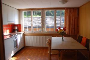 a kitchen with a table with a vase of flowers on it at Chalet Tuftbach in Grindelwald