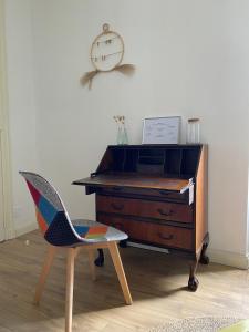 un bureau avec une chaise et un réveil sur le mur dans l'établissement Villa Bailey, à Quiberon