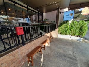 un par de bancos sentados fuera de un restaurante en Let's Zzz Bangkok en Bangkok