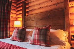 A bed or beds in a room at Tomatin - Luxury Two Bedroom Log Cabin with Hot Tub