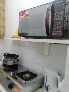 un microondas sentado en un estante sobre una estufa en Golden Nest, en Mombasa