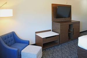 a room with a tv and a chair and a table at Comfort Inn and Suites Near Lake Guntersville in Scottsboro