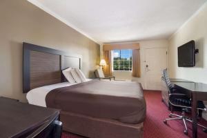 una camera d'albergo con un grande letto e una scrivania di Suburban Studios Florence I-95 a Florence