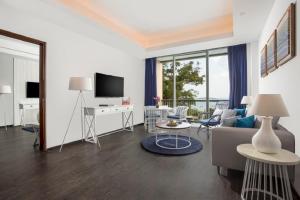 a living room with a couch and a tv at Swiss-Belresort Belitung in Tanjungbinga