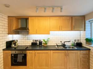 a kitchen with wooden cabinets and a sink at The Garden Flat in Exmouth