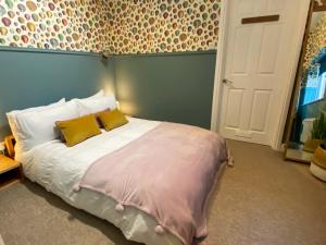 a bedroom with a large bed with two yellow pillows at The Garden Flat in Exmouth