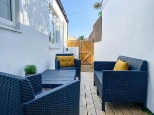 dwa niebieskie krzesła i stół na patio w obiekcie The Garden Flat w mieście Exmouth