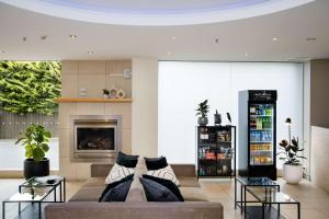 een woonkamer met een bank en een open haard bij The Terrace Hotel Adelaide in Adelaide