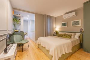 a bedroom with a bed and a desk and a chair at As Vizinhas Boutique Apartments in Porto