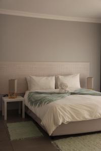 a bedroom with a large white bed with a side table at Atlantic Dunes Unit 10, Self Catering in Rand Rifles