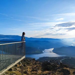 uma mulher à beira de uma montanha com vista para um lago em Casa Cabanas do Douro em Torre de Moncorvo