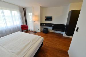 a hotel room with a bed and a desk at HOTEL illuster - Urban & Local in Uster