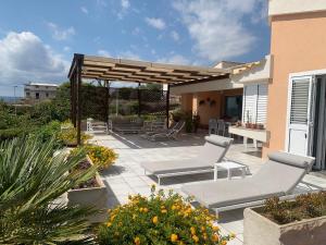 a patio with two lounge chairs and a pergola at Villa Luce in Siracusa