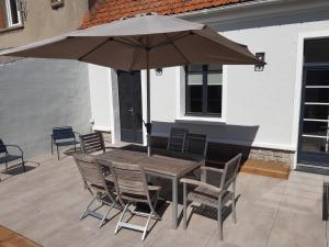a table and chairs with an umbrella on a patio at Maison de vacances-La balade des deux Caps in Audinghen