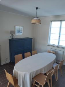 a dining room with a white table and chairs at Maison de vacances-La balade des deux Caps in Audinghen