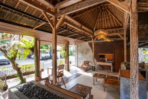 an outdoor living room with a large wooden ceiling at Bije Suite Villa Ubud in Ubud