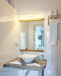 a white sink sitting under a mirror in a bathroom at Bliss Dhigurah in Dhigurah