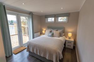 a bedroom with a bed with two lamps and a window at Sumners Ponds Fishery & Campsite in Horsham