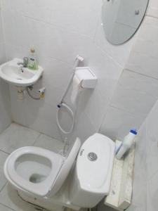 Baño blanco con aseo y lavamanos en Golden Nest, en Mombasa
