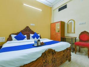 a bedroom with a large bed and a red chair at The Maurvi Inn in Jaipur