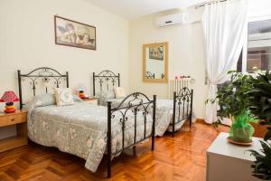 two beds in a bedroom with wooden floors at B&B Stupor Mundi in Altamura