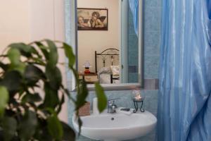 a bathroom with a sink and a mirror and a plant at B&B Stupor Mundi in Altamura