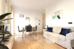 een woonkamer met een witte bank en een tafel bij Encantador Alojamiento junto al corazón de Madrid Río in Madrid