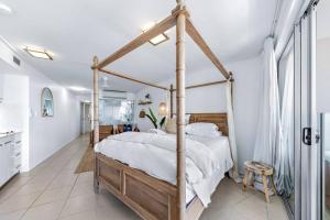 Three A Airlie Seaviews, Pool, Private Spa في شاطئ إيرلي: غرفة نوم مع سرير مظلة في غرفة