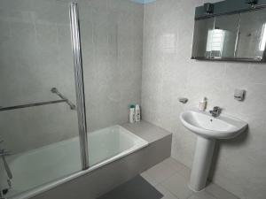 biała łazienka z umywalką, wanną i toaletą w obiekcie Low Island House w mieście Los Silos