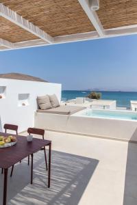 a patio with a table and a swimming pool at Citadela Paros Molos - Beachfront Maisonette with Plunge Pool in Molos Parou