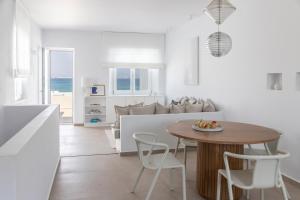 a kitchen and living room with a table and chairs at Citadela Paros Molos - Beachfront Maisonette with Plunge Pool in Molos Parou
