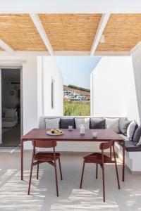 un soggiorno con tavolo e divano di Citadela Paros Molos - Beachfront Maisonette with Plunge Pool a Molos Parou