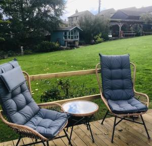 2 sillas y una mesa de centro en el patio en The Hut in the Orchard @ Yorecroft en Aysgarth