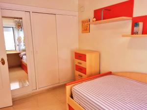 um pequeno quarto com uma cama e um closet em APARTAMENTO EN PRIMERA LINEA DE PLAYA CON INCREIBLES VISTAS em Santa Pola