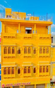 un edificio amarillo con balcón en la parte superior en Hotel Ajeet Palace, en Jaisalmer