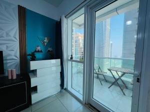 Habitación con una gran ventana de cristal y una mesa. en skynest holiday homes 1bedroom apartment 4003, en Dubái