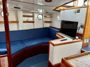 un vagón de tren con sofá azul y TV en salidas en barco, en Premiá de Mar