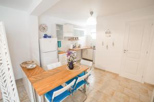 a kitchen with a wooden table and a refrigerator at AGIAZI Poros Summer House in Galatas
