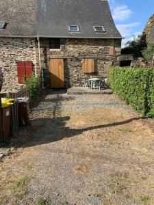 une maison en pierre avec une table et un banc dans l'établissement Gîte en Bretagne Sud Ty Nikolaz, à Sainte-Marie