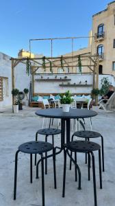 uma mesa e dois bancos sentados ao lado de um edifício em Hostel On em Sliema