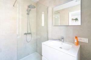 uma casa de banho branca com um lavatório e um chuveiro em City Centre Loft Residence em Antuérpia